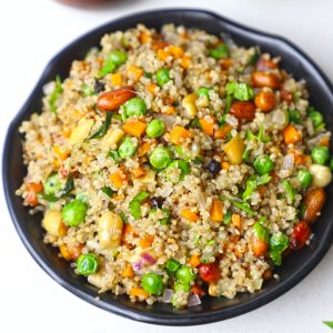 aerial shot of quinoa upma in a black bowl.
