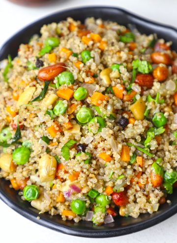 aerial shot of quinoa upma in a black bowl.