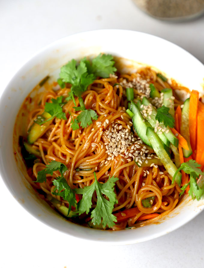 side close up shot of vegan bibim guksu served in a white ceramic bowl.