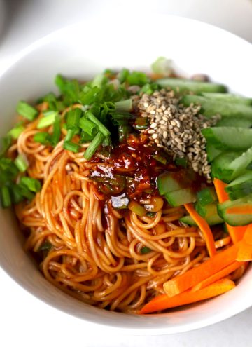 side close up shot of vegan Bibim Guksu served in a white bowl.