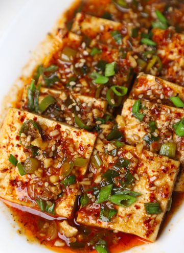 side close up shot of braised tofu served in a white platter.