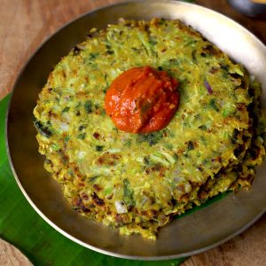 side close up shot of jowar thalipeeth served with chutney in a kansa plate.