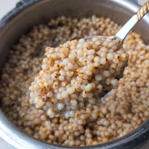 side close up shot of cooked whole jowar in a pressure cooker.
