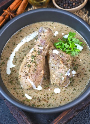 aerial shot of chicken kali mirch served in a black bowl.