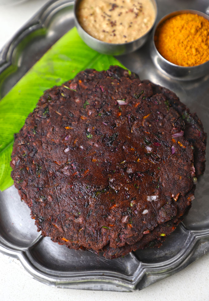 aerial angular shot of ragi adai stacked on a stainless steel plate.