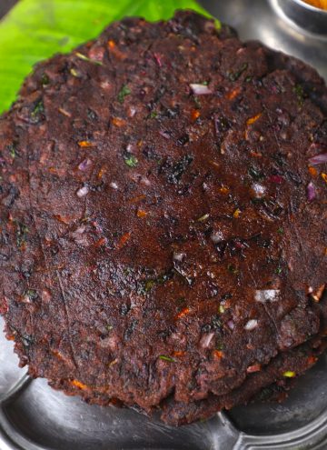 side aerial shot of ragi adai stacked in a stainless steel platter.