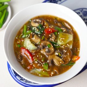 aerial shot of mushroom in ginger garlic sauce served in a white bowl.