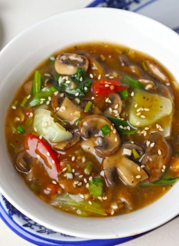 aerial shot of mushroom in ginger garlic sauce served in a white bowl.