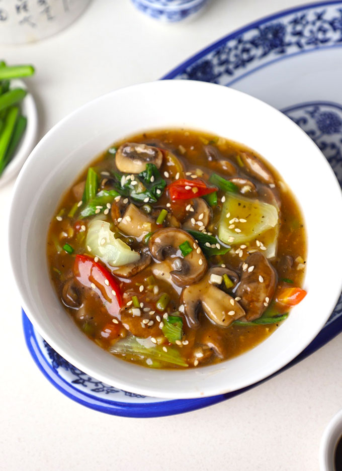 aerial shot of mushroom in ginger garlic sauce served in a white bowl.
