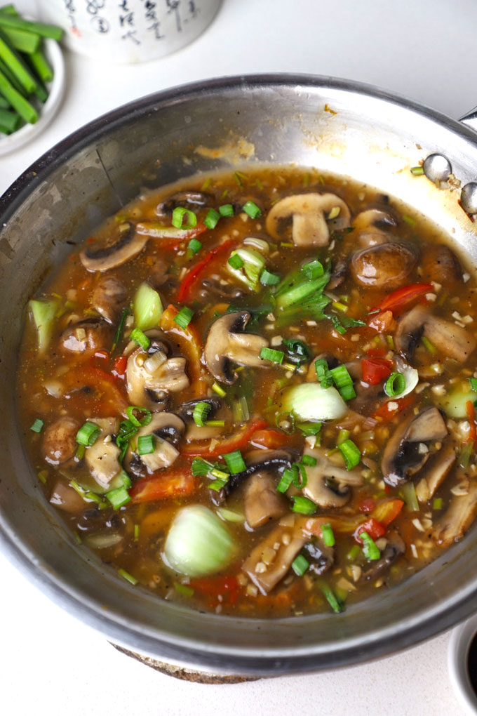 aerial shot of mushroom in ginger garlic sauce served in a stir fry pan.