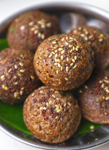 side close up shot of ragi appe stacked on a steel bowl.
